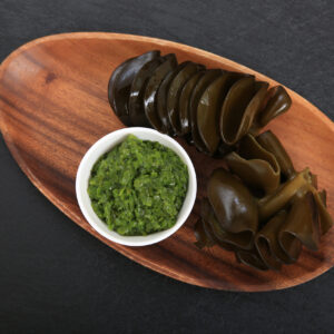 Seaweed and seaweed powder on a wooden dish on a dark gray background