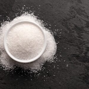 Magnesium powder spilling out of a white bowl on a black slate countertop.